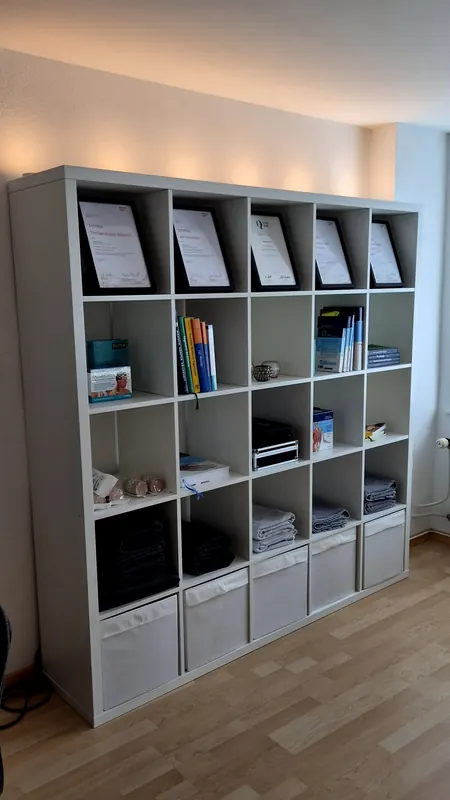 Regal mit Diplomen, Fachbüchern und Handtüchern