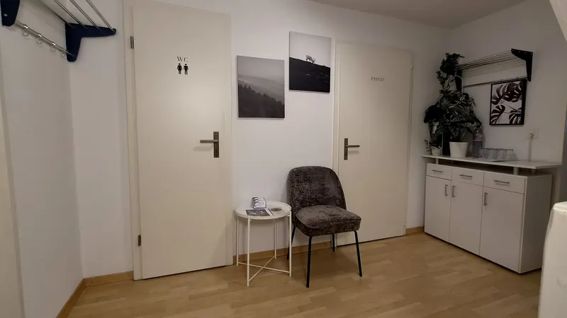 Wartebereich mit Sessel, Garderobe und Sideboard